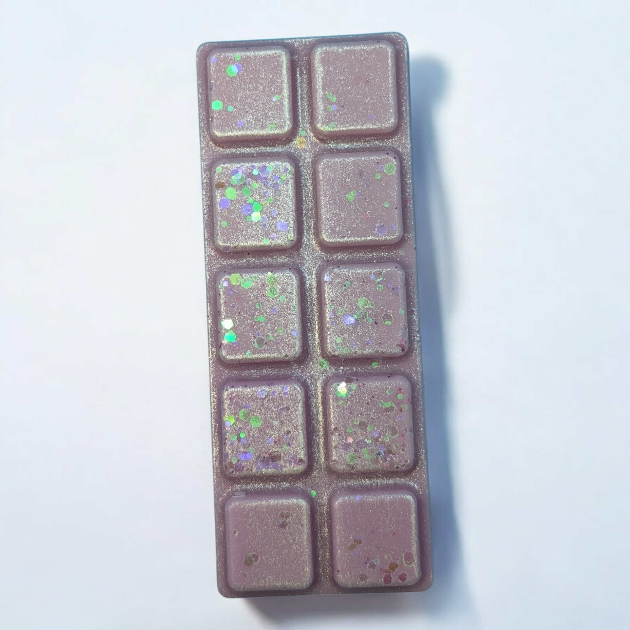 Purple shimmery and glittery wax bar on a white background