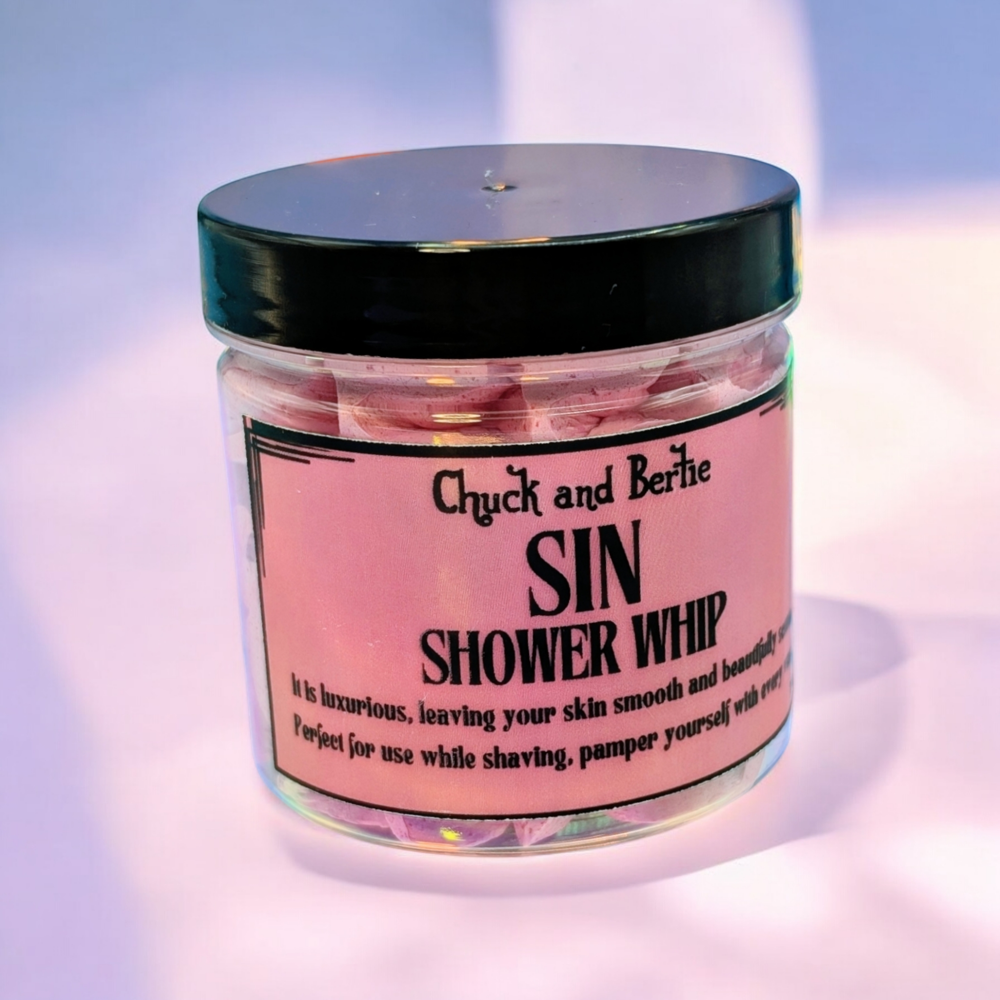 2 jars of shower whip in a light rose shade. The background is bright and minimalist